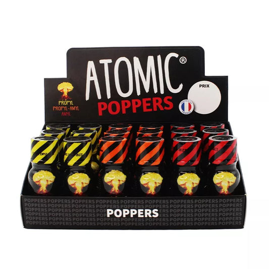 on voit sur un fond blanc un présentoir en carton noir du poppers Atomic. On voit plusieurs flacons jaune orange et rouge, ils ont tous une image d'un champignon atomique sur leur flacon.